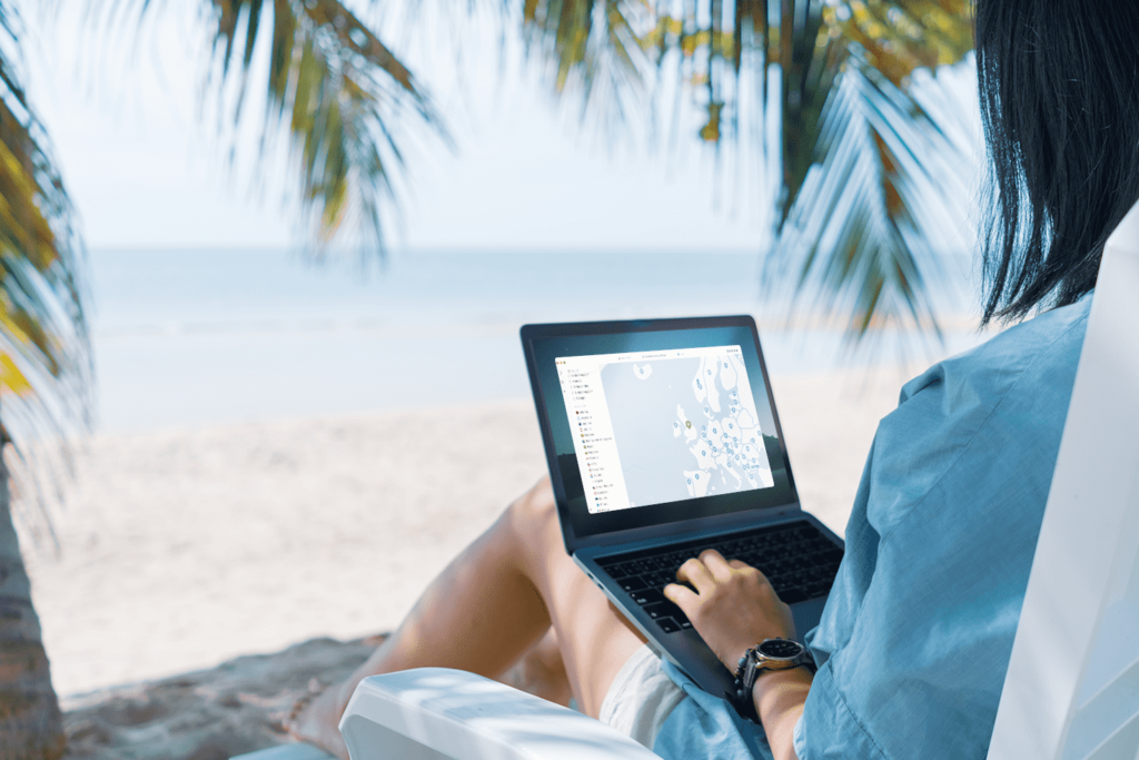 a person using macos laptop whilst sitting by the beach