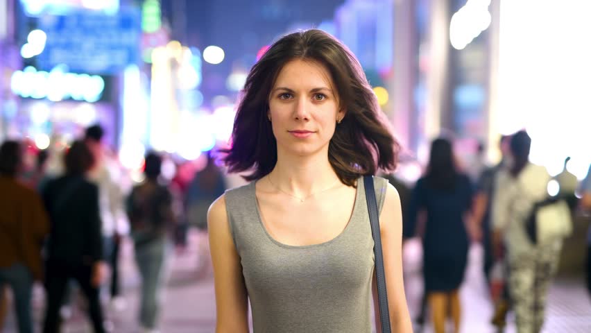 confident woman with the crowd in the background in a busy street